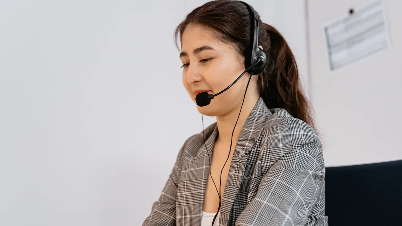 Une conseillère clientèle casquée répond à un appel depuis son bureau