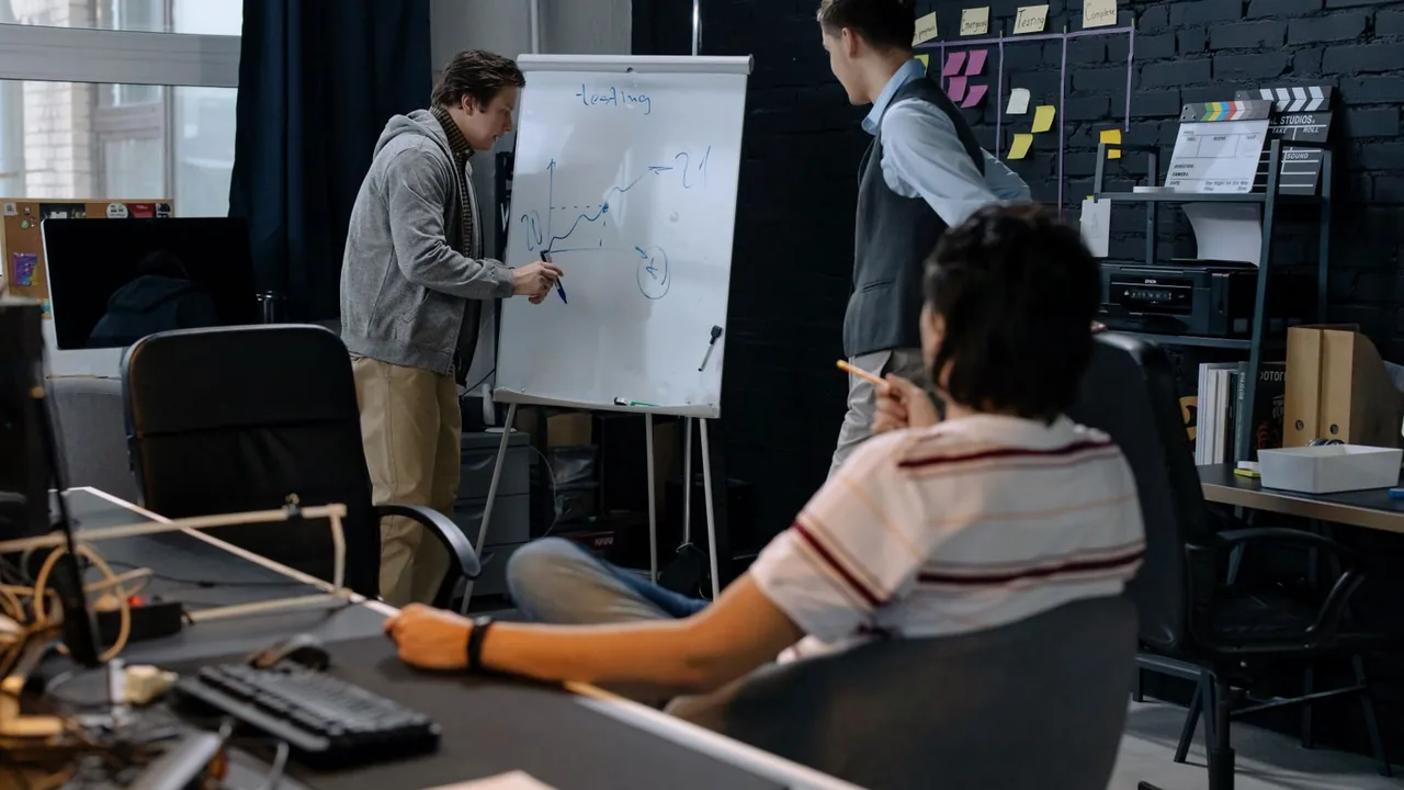Une équipe réfléchit devant un tableau blanc dans un bureau de startup