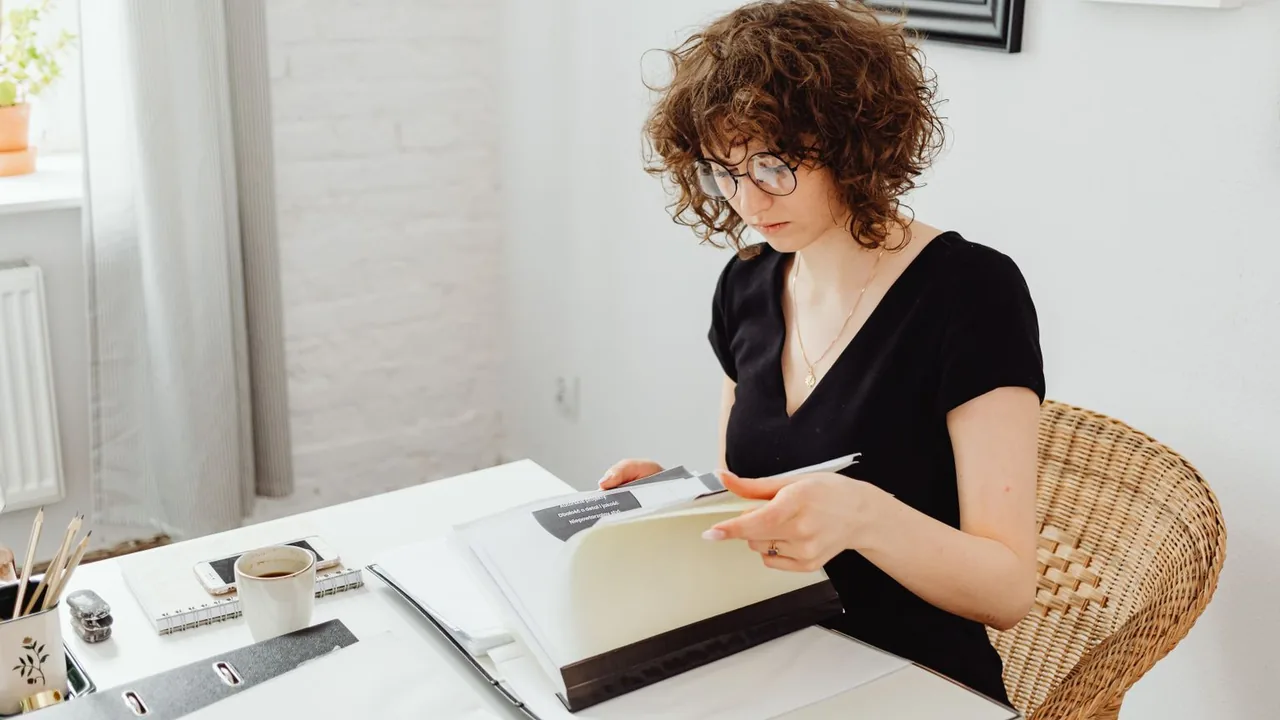 Femme lisant attentivement des documents à son bureau