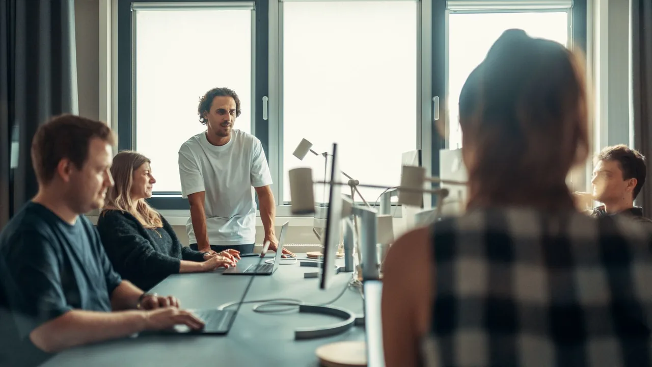 Équipe en discussion lors d'une réunion dans un bureau vitré