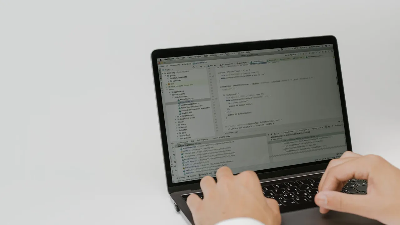 Deux mains sur le clavier d'un ordinateur portable, sur fond blanc.