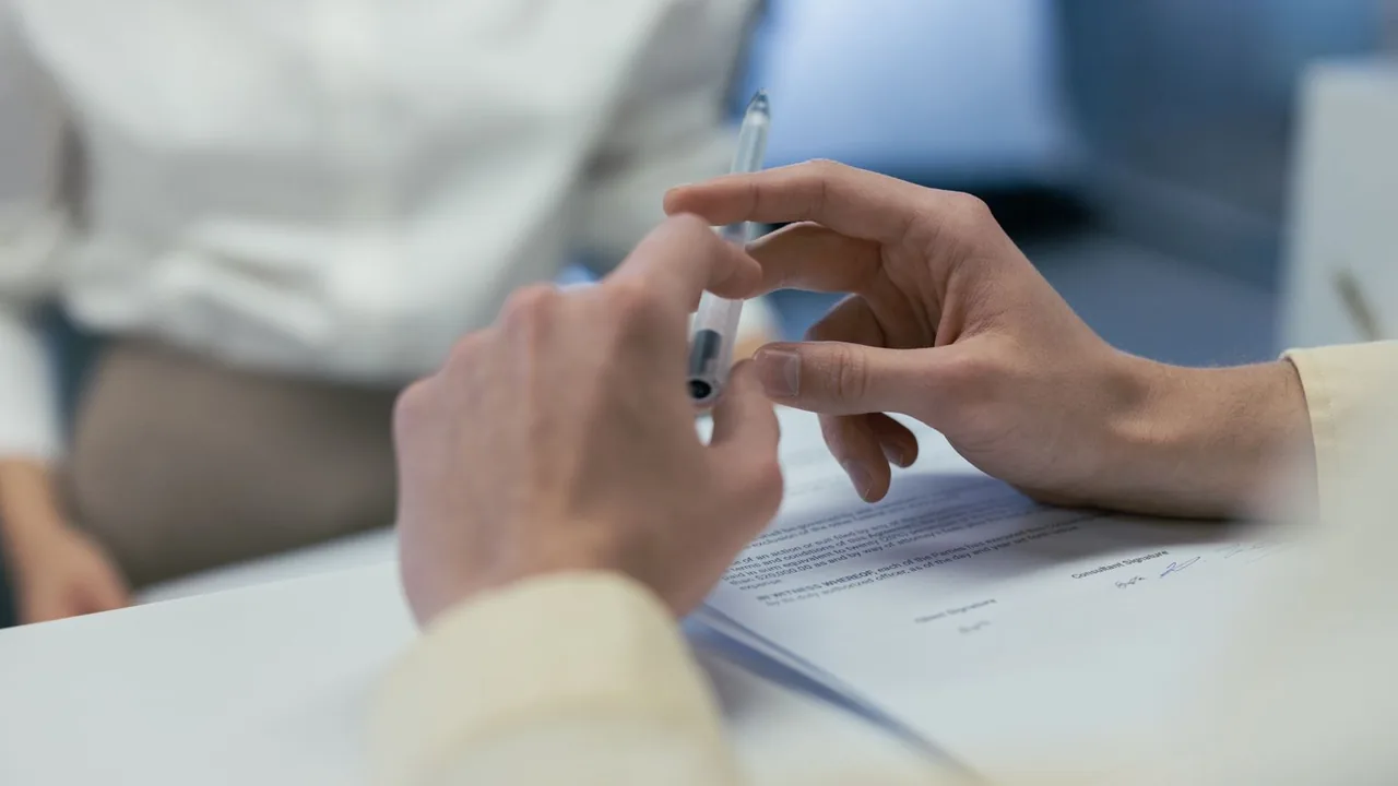 Des mains tenant un stylo au-dessus d'un document lors d'un échange