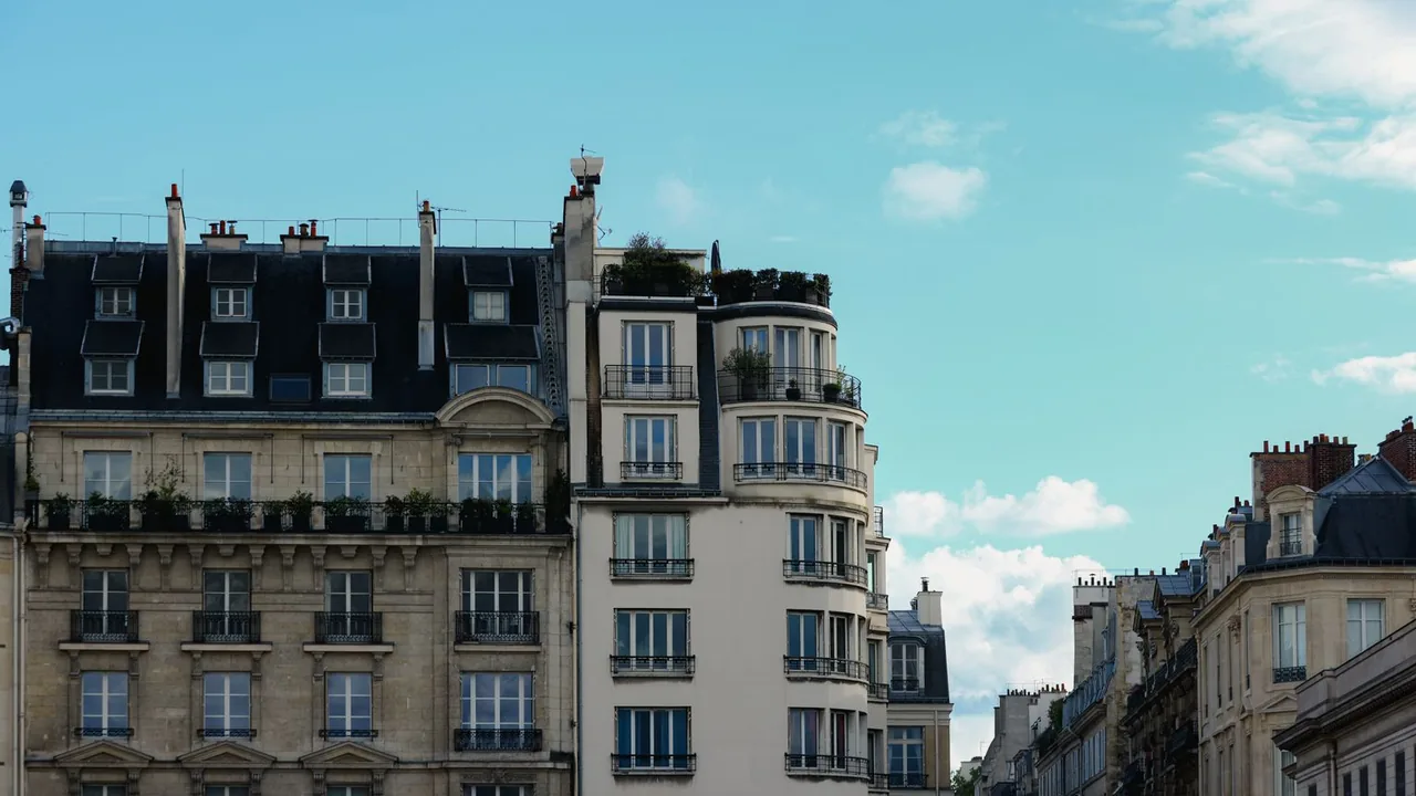 Façades d'immeubles parisiens aux toits d'ardoise sous un ciel bleu