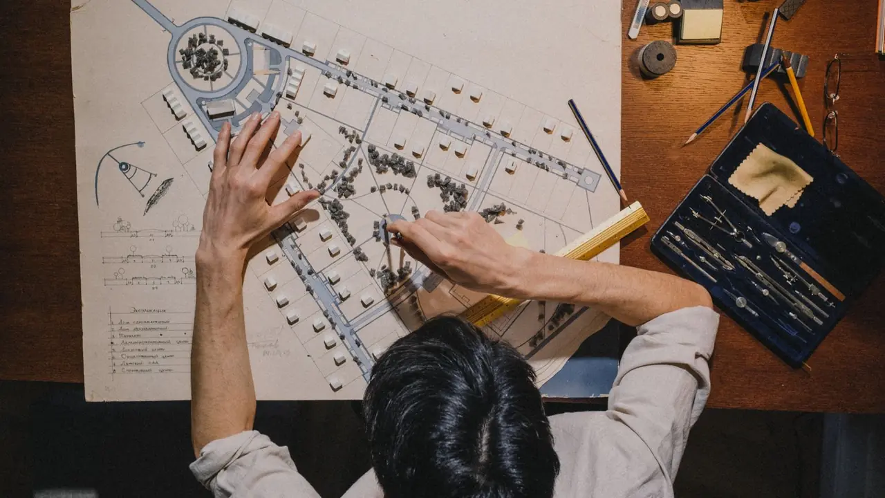 Vue du dessus d'un urbaniste qui travaille sur le plan d'un quartier avec des instruments de précision