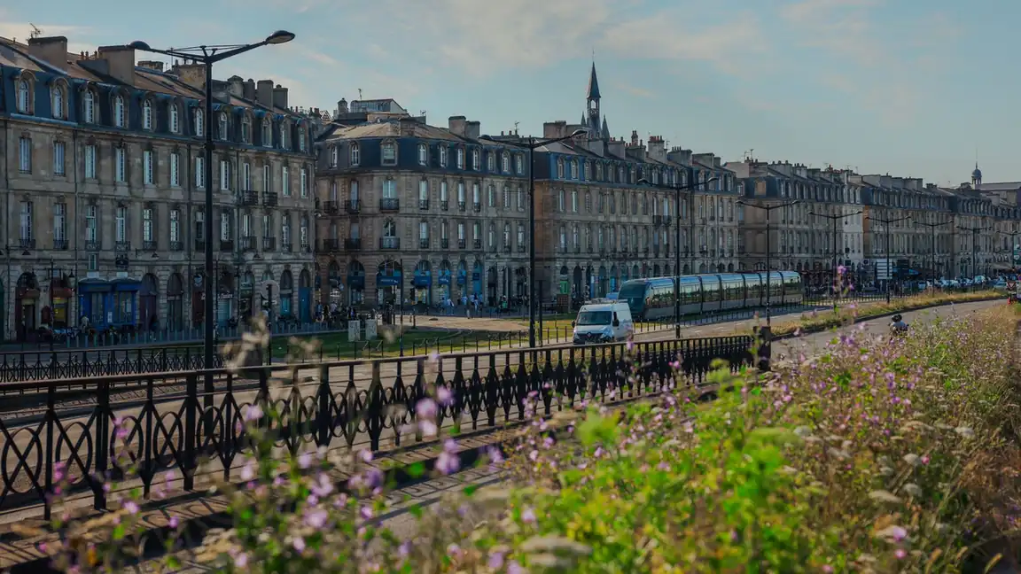 Quais d'une grande ville française bordés d'immeubles anciens, un tramway au loin