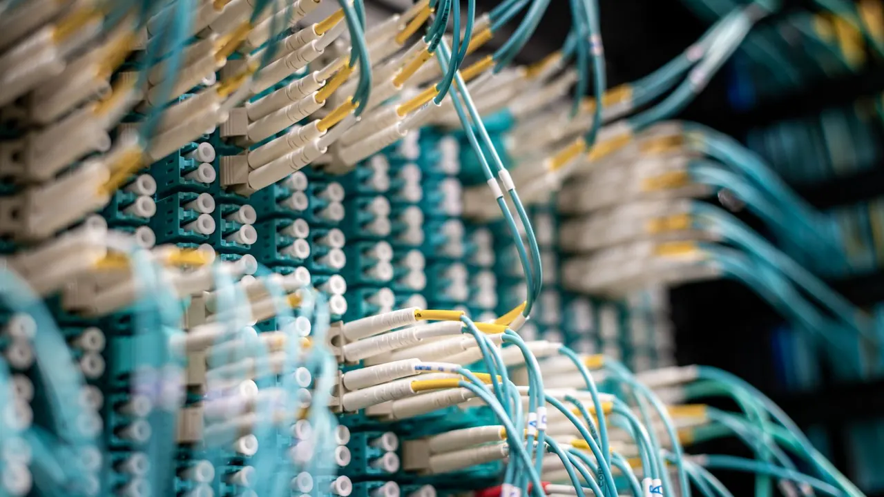 Faisceaux de câbles à fibre optique reliés à une baie de connexion dans un centre de données