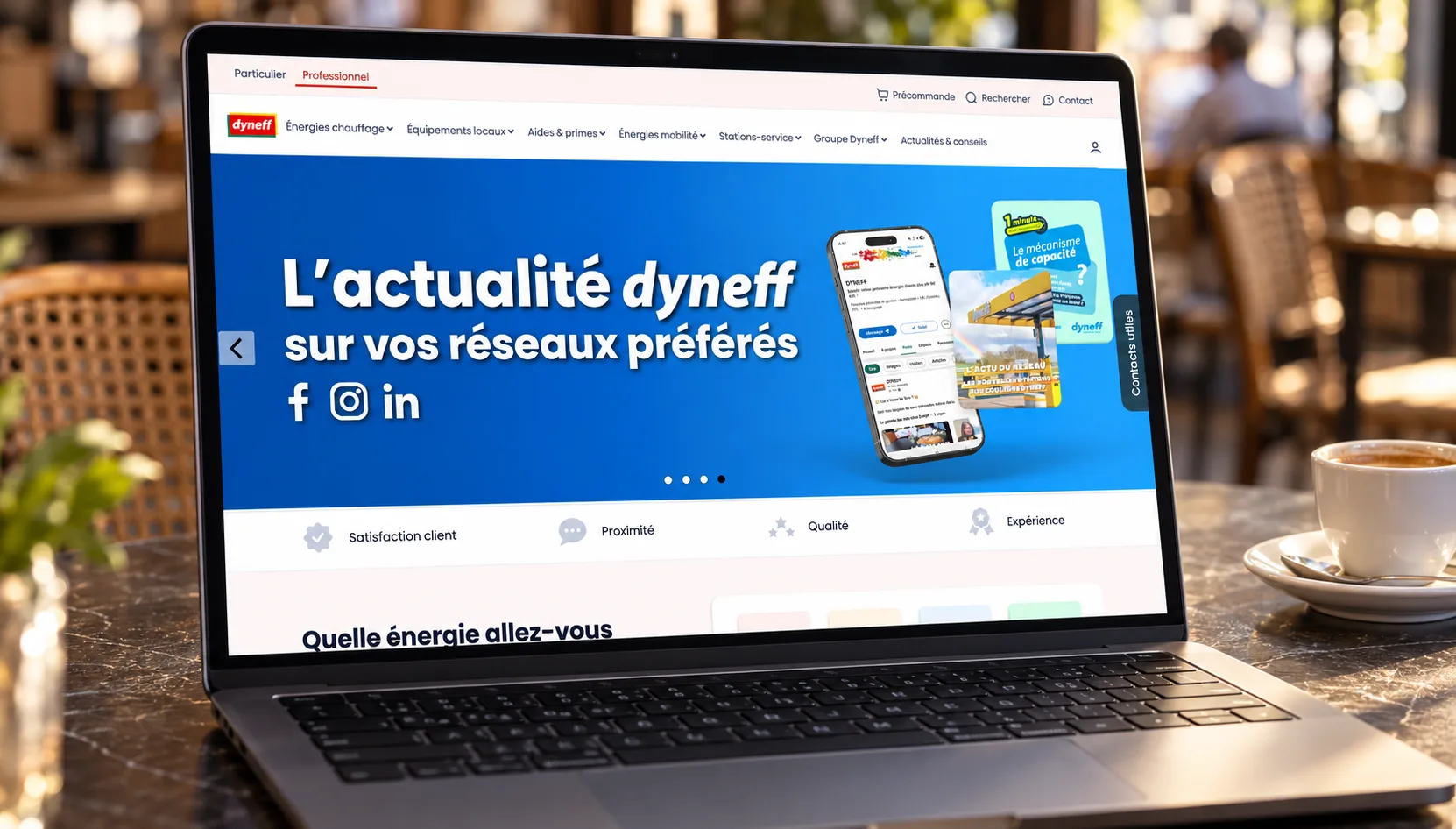Maquette de l'accueil professionnel du site de Dyneff sur un ordinateur portable posé dans un café : onglet « Professionnel » actif, bandeau « L'actualité dyneff sur vos réseaux préférés » et engagements « Satisfaction client », « Proximité », « Qualité » et « Expérience »