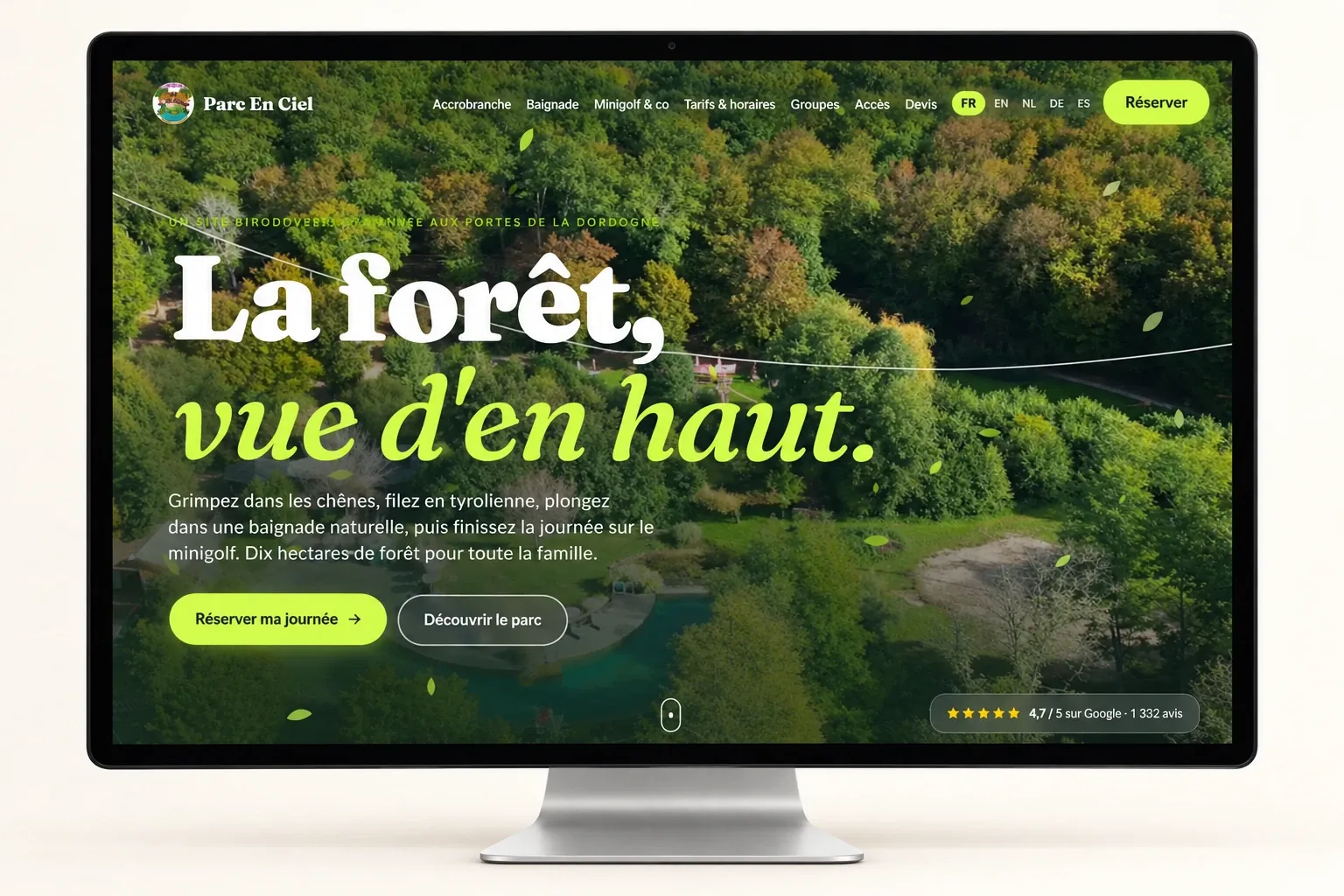 Maquette de l'accueil du site Parc En Ciel sur un écran : vue aérienne de la forêt, titre « La forêt, vue d'en haut. », boutons « Réserver ma journée » et « Découvrir le parc », note Google en bas à droite