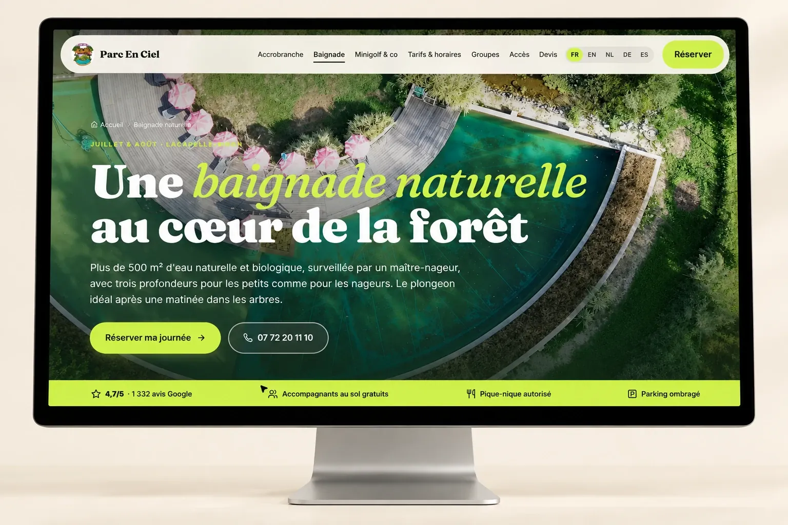 Maquette de la page Baignade de Parc En Ciel : vue aérienne du bassin naturel et de ses parasols, titre « Une baignade naturelle au cœur de la forêt »