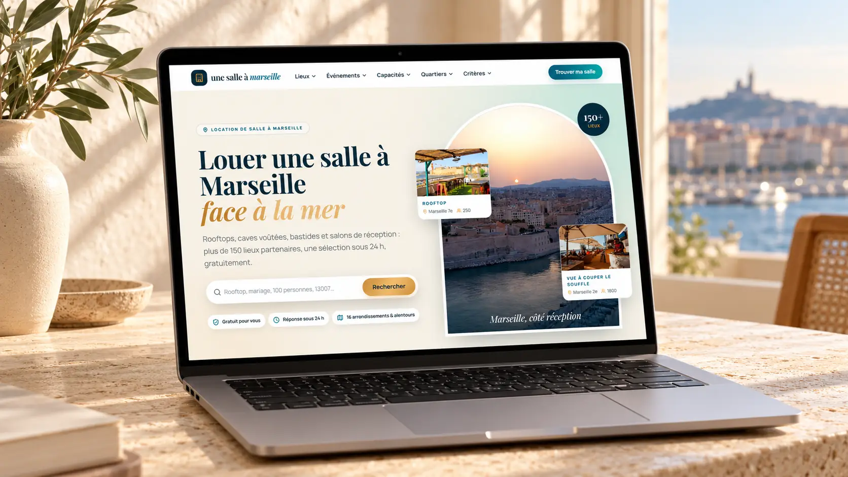 Maquette de l'accueil du site Une salle à Marseille sur un ordinateur portable, vue sur Notre-Dame-de-la-Garde : titre « Louer une salle à Marseille face à la mer », barre de recherche, badges « Gratuit pour vous » et « Réponse sous 24 h »