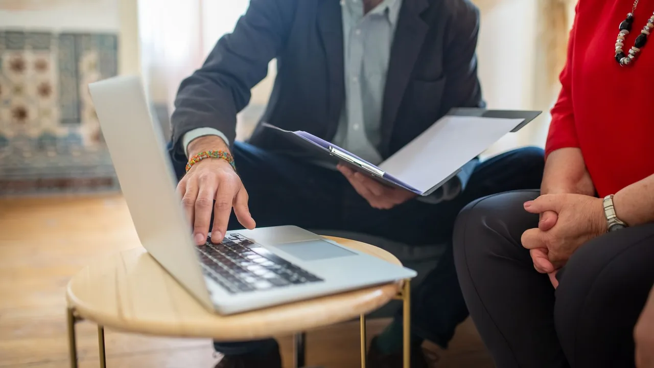 Réunion d'équipe autour d'un ordinateur portable et de documents, pour organiser les outils partagés de l'entreprise