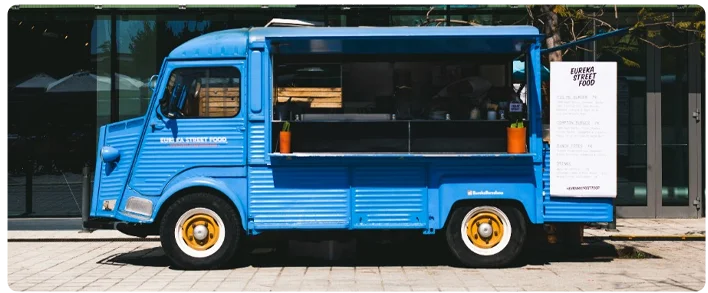 A blue truck is parked on the side of the street